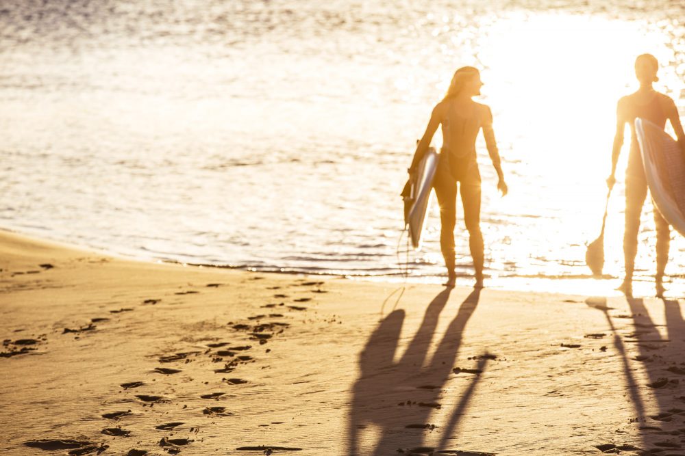 girls-standing-on-beach-with-paddleboards-at-currumbin-creek