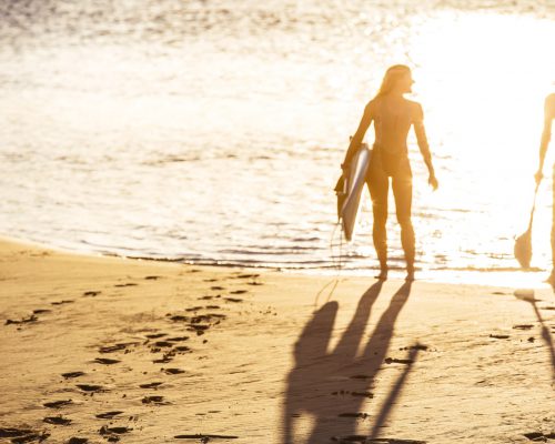 girls-standing-on-beach-with-paddleboards-at-currumbin-creek